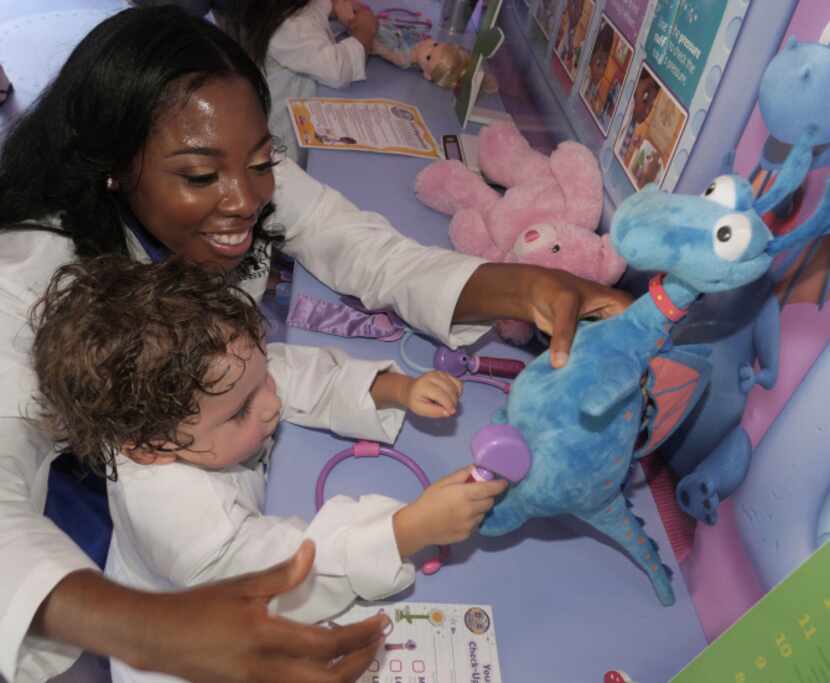 Dr. Myiesha Taylor helps A.J. Vasquez, 2, of Fort Worth check a dragon's reflexes. In...