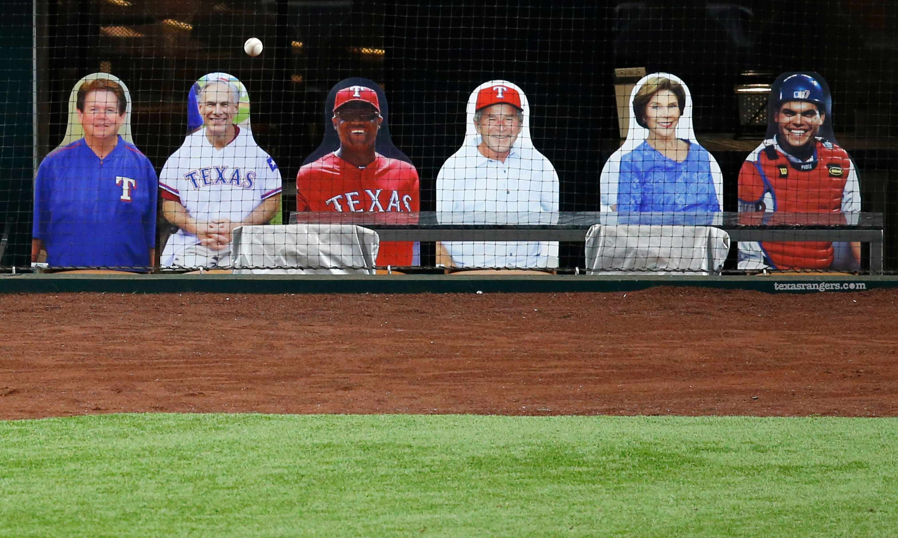 A foul ball bounces towards DoppelRangers, including former president George Bush during a...