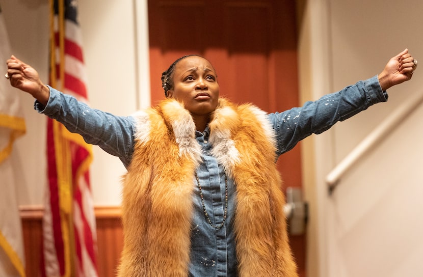 September Calhoun lifts her arms while listening to worship music before the prayer service...