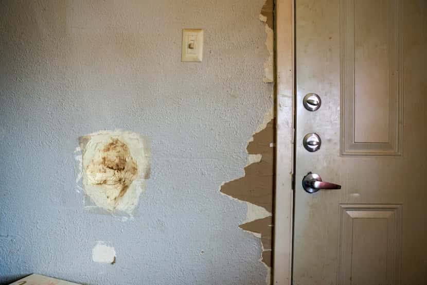 Holes and missing paint line the wall near the front door of Destiny Morris’ home at the...