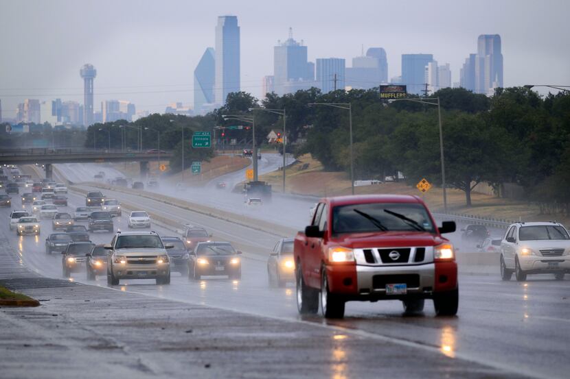 Drivers navigate Interstate 35W south of downtown Dallas during a light rain.