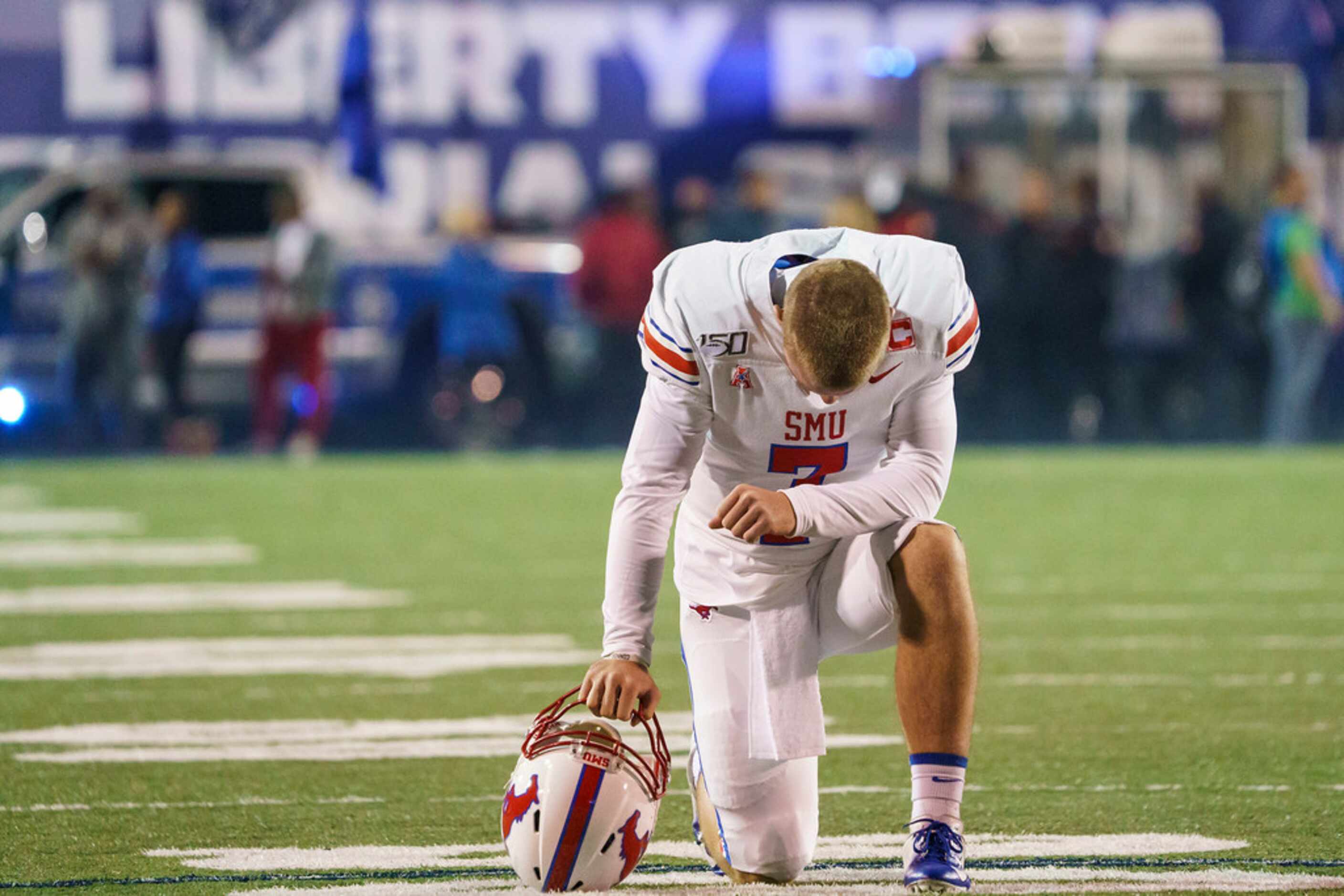 SMU quarterback Shane Buechele kneels in prayer before an NCAA football game against Memphis...