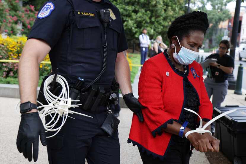 WASHINGTON, DC - JULY 29: U.S. Rep. Sheila Jackson Lee (D-TX) (R) is arrested by a member of...