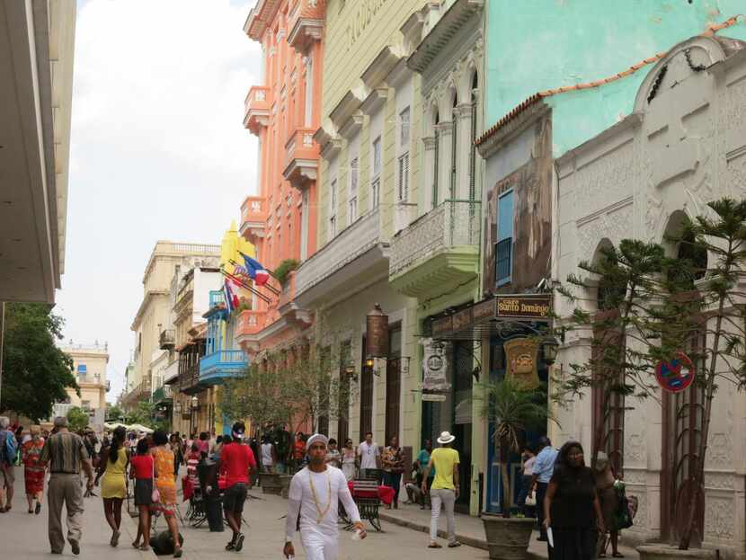 The streets of Havana are lined with architecturally interesting buildings painted in pastel...