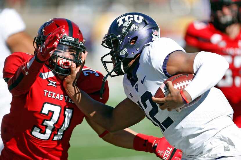 TCU's Shawn Robinson (12) tries to run around Texas Tech's Justus Parker (31) during the...