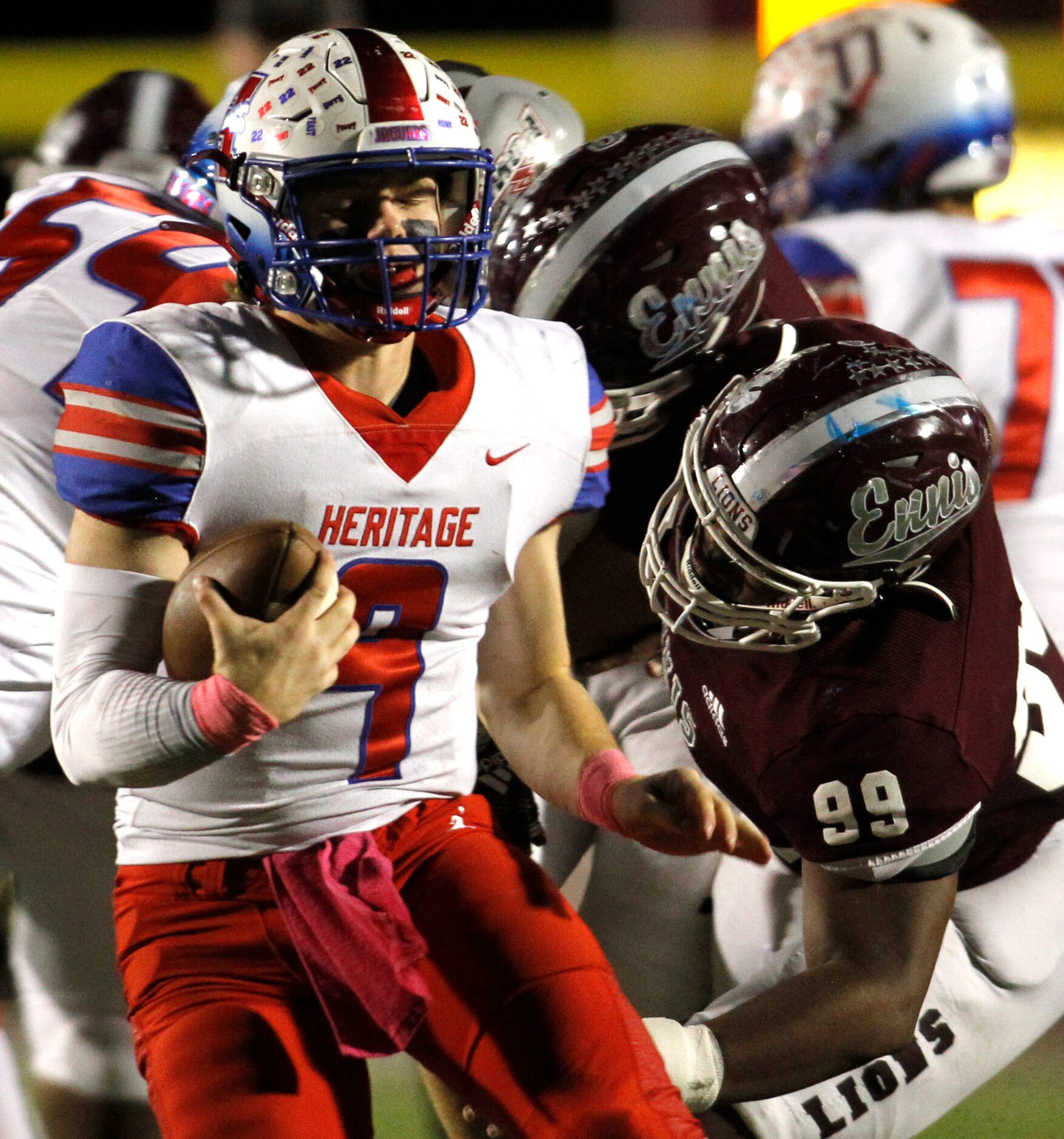 Midlothian Heritage quarterback Carter Rutenbar (9), left, turns to elude the tackle attempt...