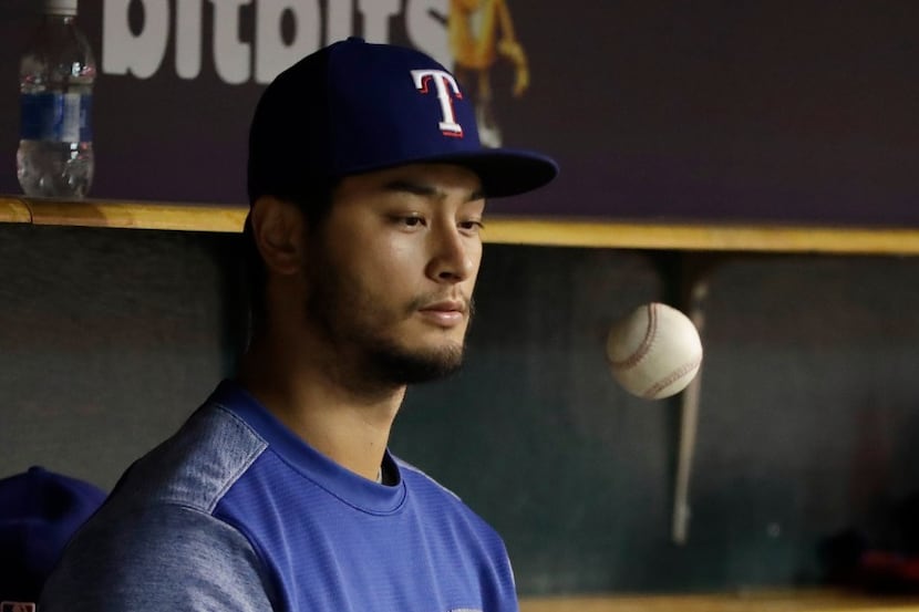 Rangers pitcher Yu Darvish tosses a ball during the team's game against the Detroit Tigers...