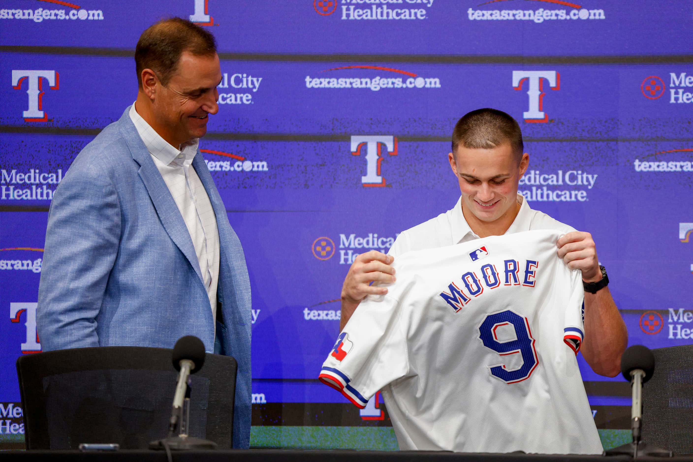 Texas Rangers first-round pick Malcolm Moore puts on his Rangers jersey during a press...