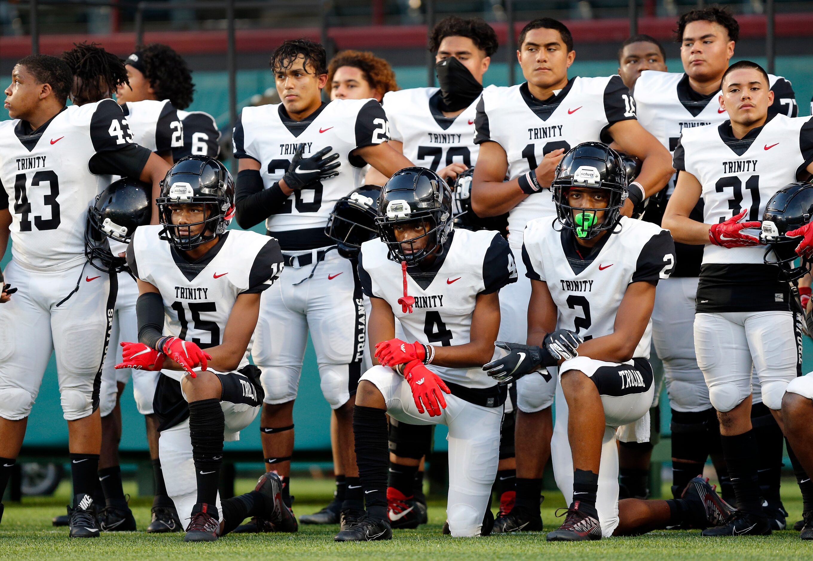 Several Euless Trinity football players including Pofele Ashlock (15), Max Bosilikwa (4) and...