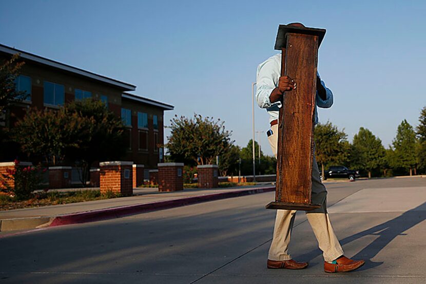  Jahi Adisa Bakari removes his podium after hosting a press conference commemorating the two...