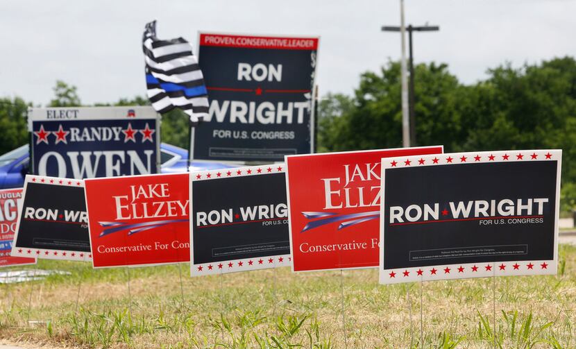 Competing signs for US Congressional candidates in District 6 stand outside the Ellis County...