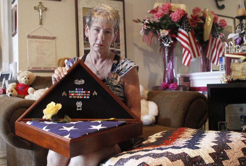 Margy Agar received a flag and ribbons at the funeral of her daughter, Kim Agar, who died...
