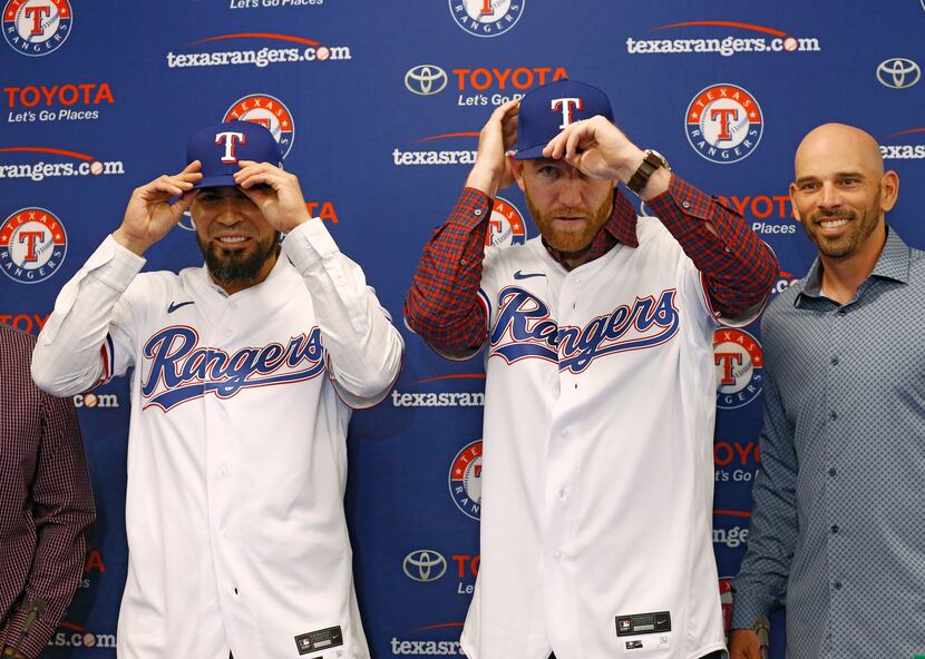 Texas Rangers catcher Robinson Chirinos (left) and third basemen Todd Frazier (center) put...