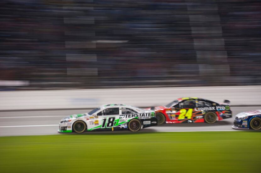 Kyle Busch (18) battles Jeff Gordon (24) for the lead of the Sprint Cup NRA 500 at Texas...