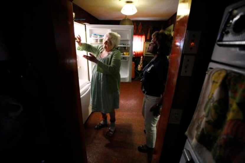 
Caseworker Valencia Hooper inspects Minnie Nobel's refrigerator in order to make sure she...