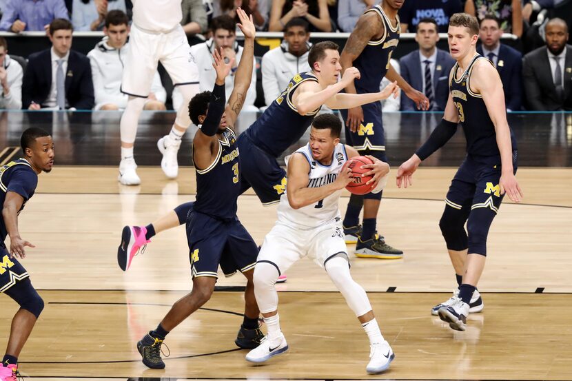 SAN ANTONIO, TX - APRIL 02: Jalen Brunson #1 of the Villanova Wildcats is defended by Zavier...