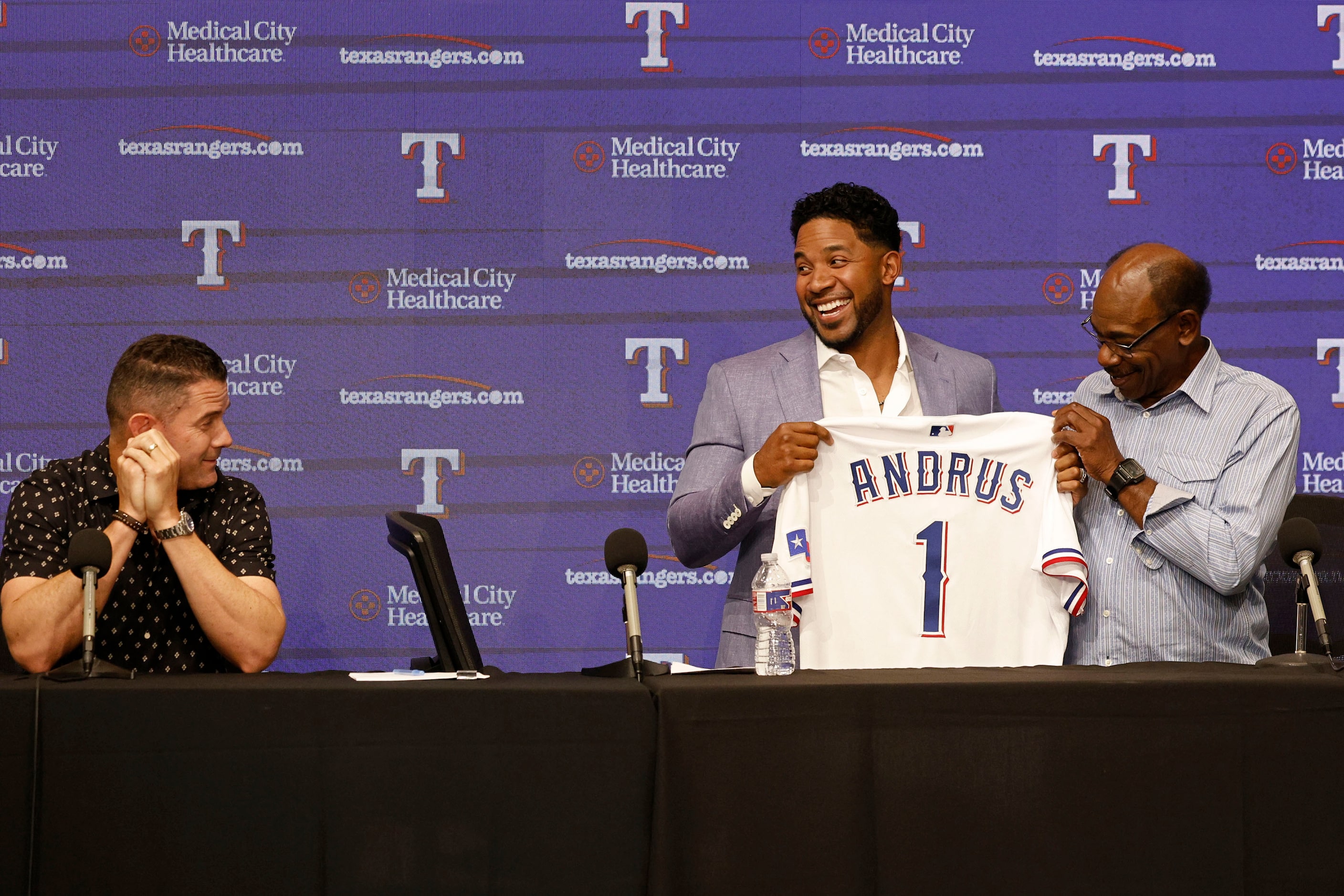 Texas Rangers' Elvis Andrus, center, holds his jersey with Los Angeles Angels Manager Ron...