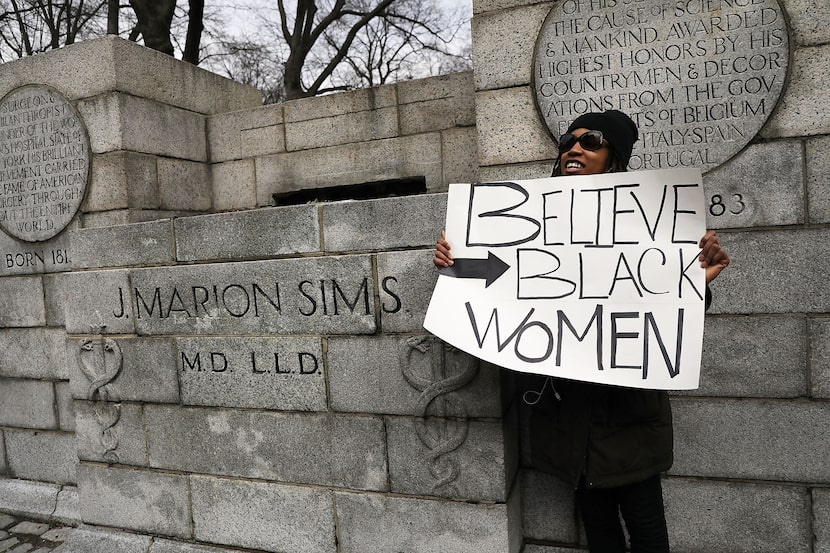 A woman stands beside the empty pedestal where a statue of J. Marion Sims, a surgeon...