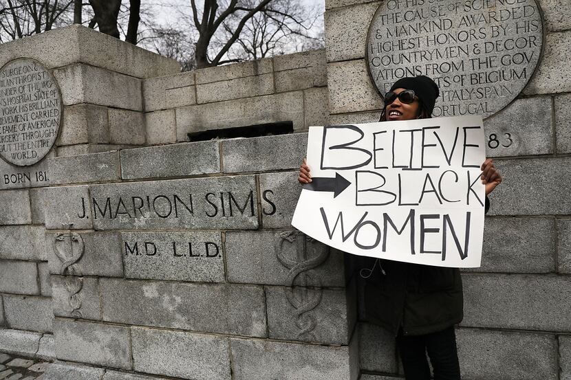 A woman stands beside the empty pedestal where a statue of J. Marion Sims, a surgeon...