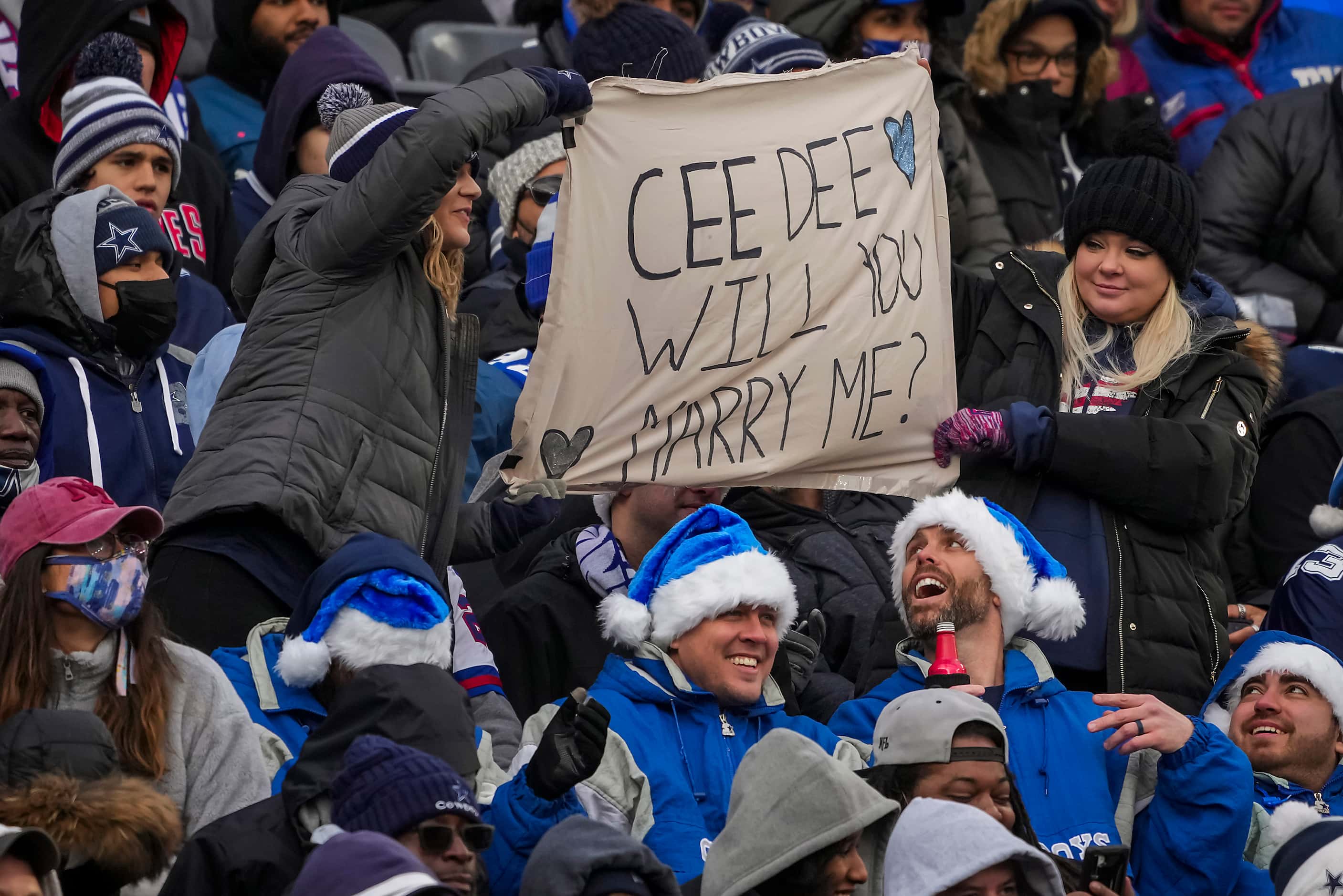 Fans hold a sign trying to get the attention of Dallas Cowboys wide receiver CeeDee Lamb...