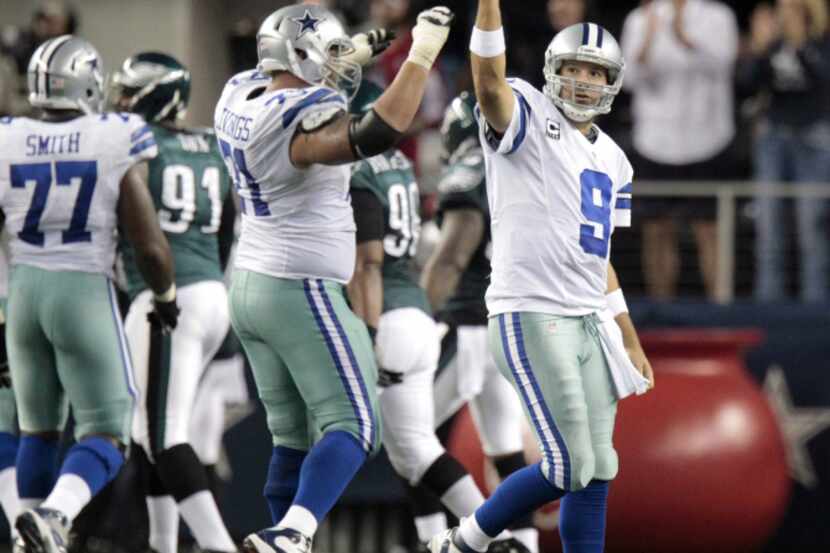 Dallas Cowboys quarterback Tony Romo (9),  celebrates a touchdown by wide receiver Miles...