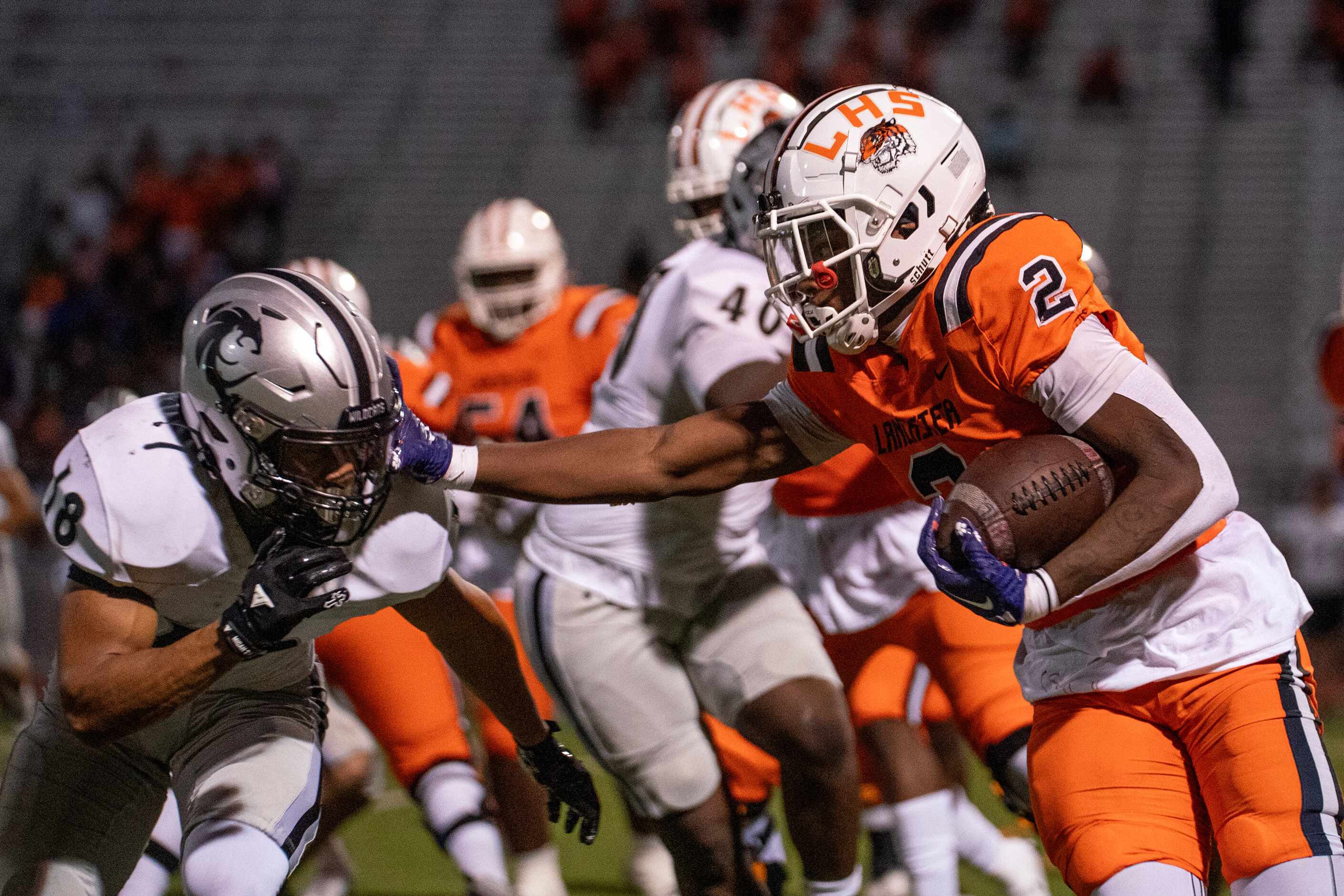 Lancaster senior running back Kewan Lacy (2) stiff arms Denton Guyer senior defensive back...