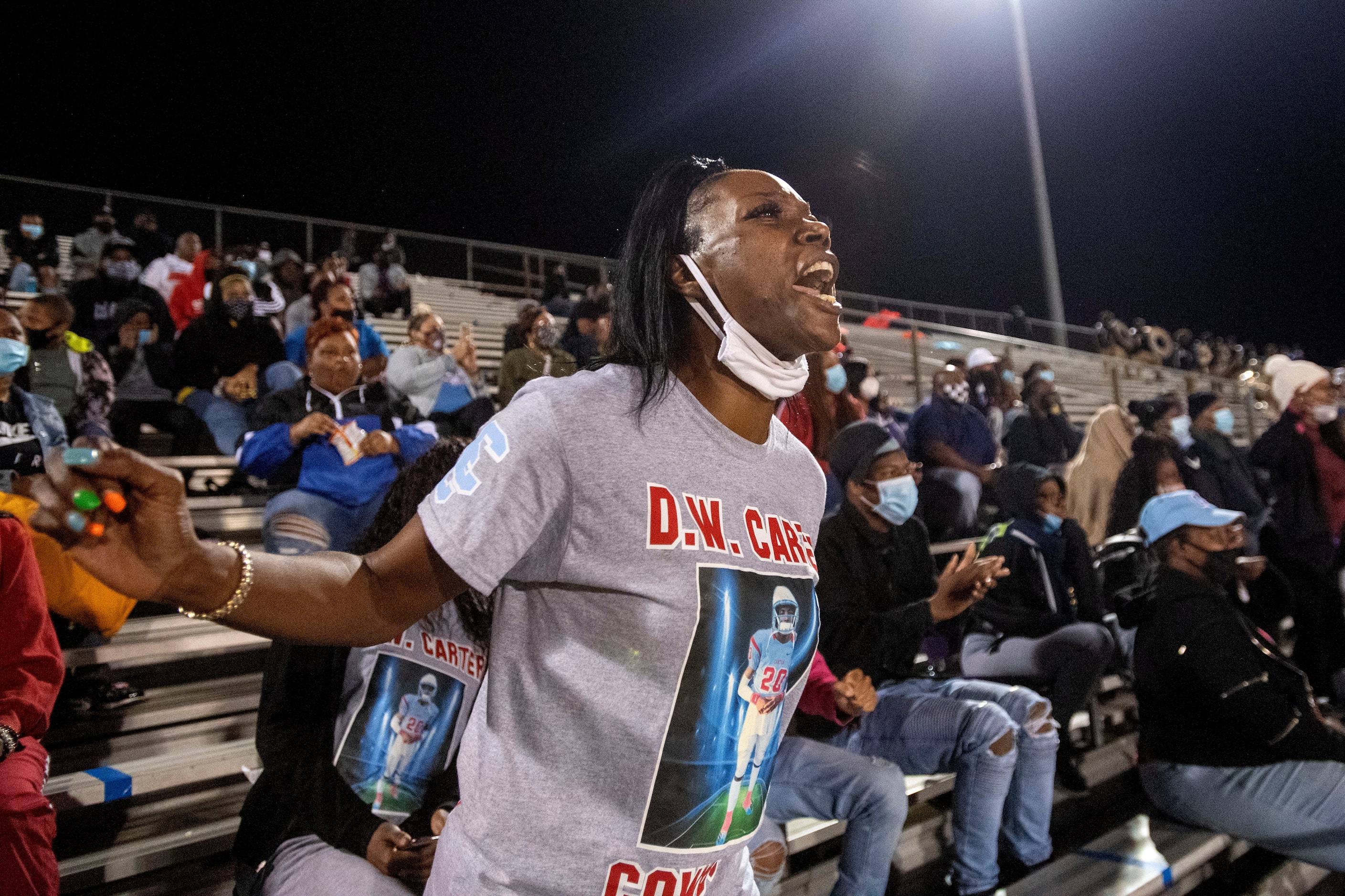 Keisha Mitchell, mother of Carter senior defensive back Jy’Quavion Vinson, yells from the...