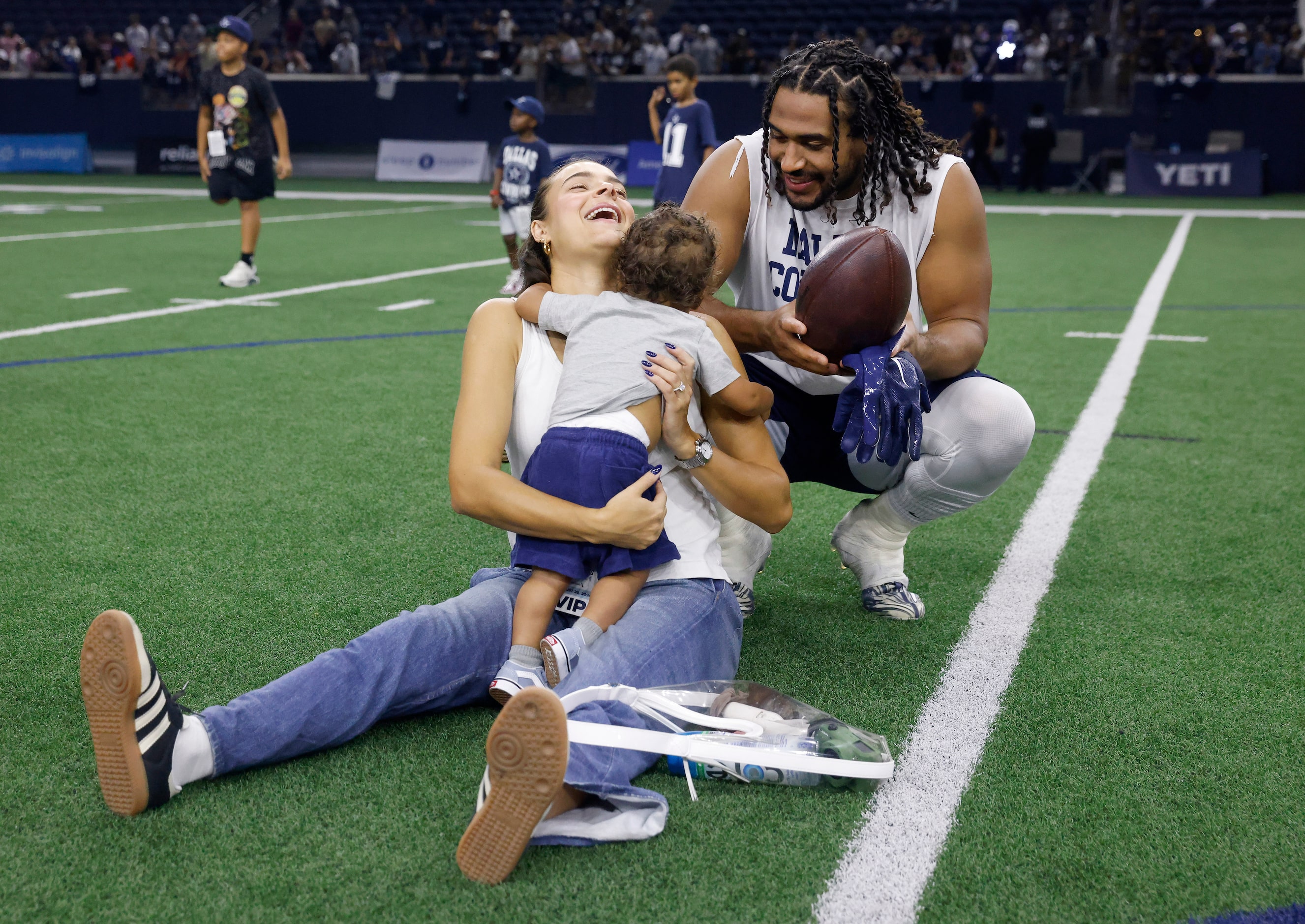 Dallas Cowboys linebacker Eric Kendricks, his wife Ally and son Knight play with a football...