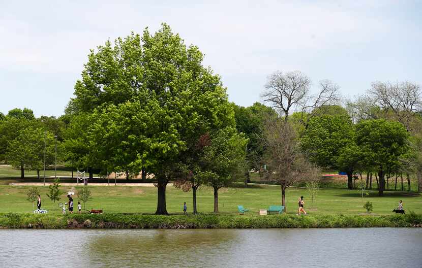 People make their way around a pond at Bob Woodruff Park in Plano.