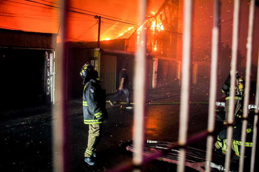 Un bombero mira al cielo mientras un incendio forestal arrasa edificios en Viña del Mar,...
