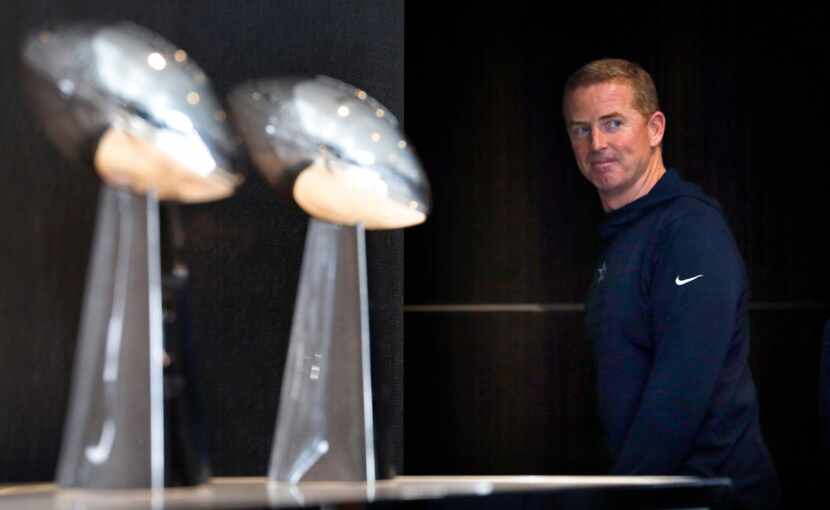 Dallas Cowboys head coach Jason Garrett passes by past Super Bowl trophies following his...