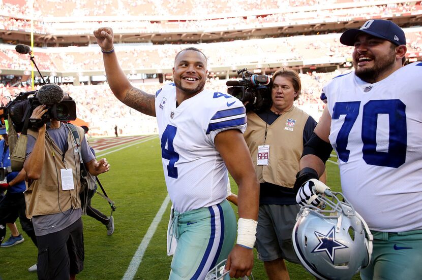 Dallas Cowboys quarterback Dak Prescott (4) and offensive guard Zack Martin (70) walk off...