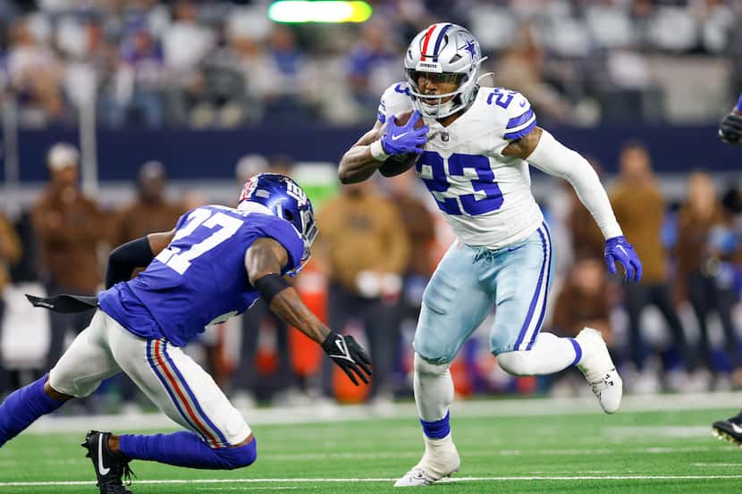 Dallas Cowboys running back Rico Dowdle (23) avoids a tackle from New York Giants safety...