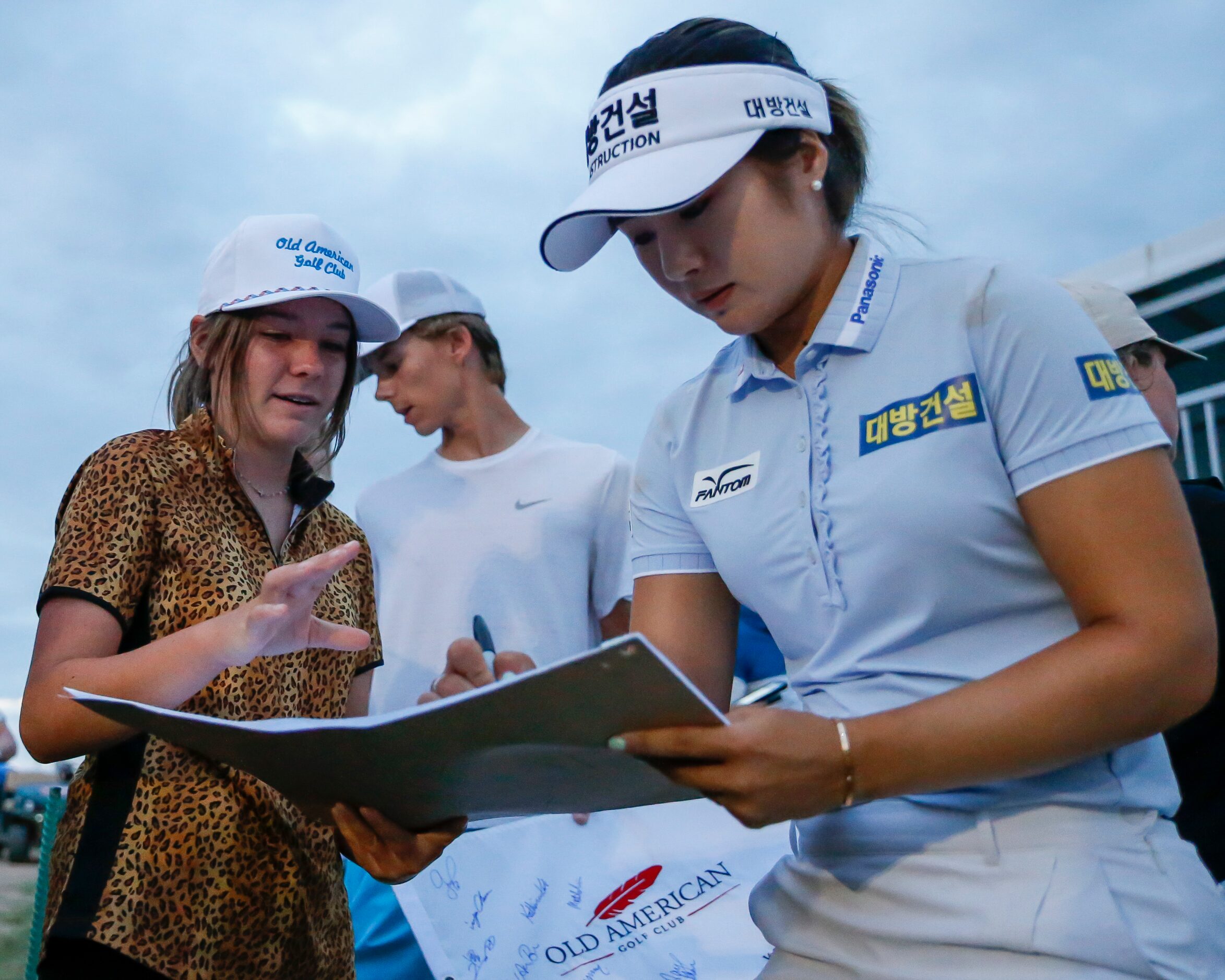 Professional golfer Jeongeun Lee6 (right) signs a pin flag for Emma Darnold, 14, of Andrews,...