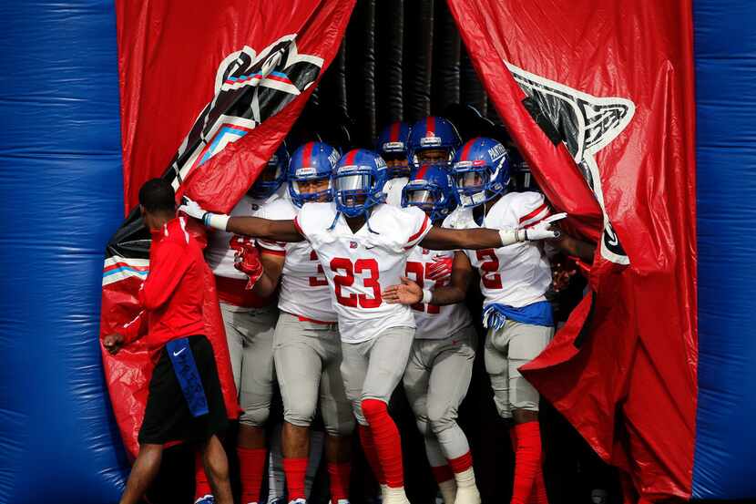 Marquez Beason (23) leads the Duncanville team onto the field against Lewisville during...