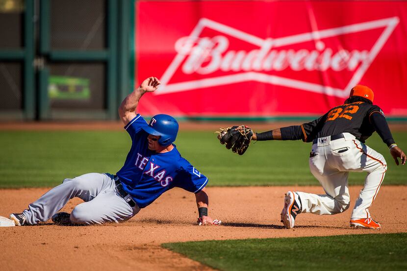 Texas Rangers outfielder Scott Heineman is safe at second base past the tag from San...