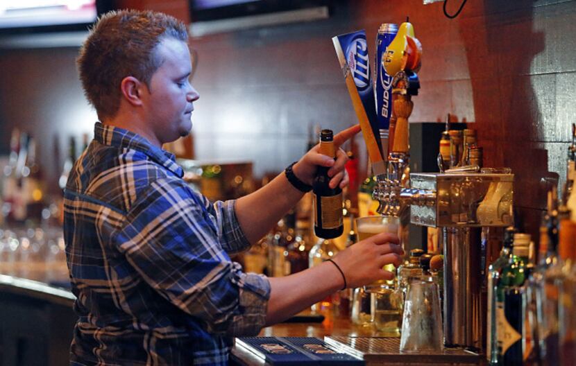 Lee Lewellen of Dallas tends bar at Grover's in Frisco on Thursday night, August 1, 2013.