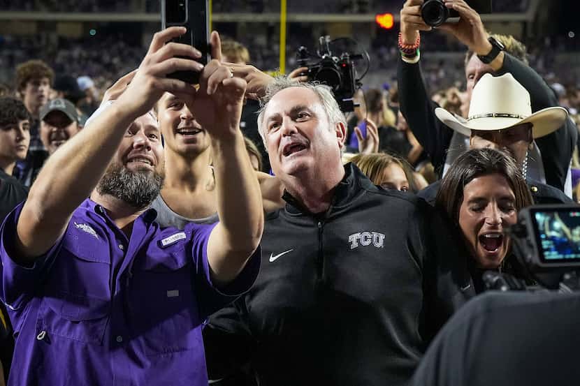 TCU head coach Sonny Dykes poses for selfies on the field after a victory over Kansas State...
