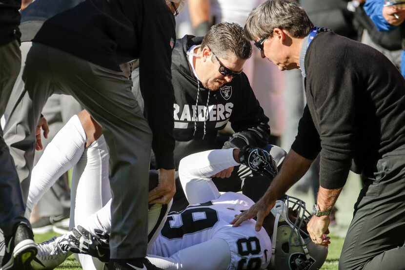 Oakland Raiders trainers look over Oakland Raiders wide receiver Amari Cooper (89) during...