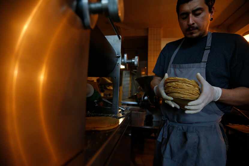 Jesús Saldivar toma tortillas recien salidas de la máquina del Molino El Pujol, en la Ciudad...