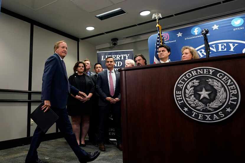 Texas Attorney General Ken Paxton (left) arrives with his staff to makes a statement at his...