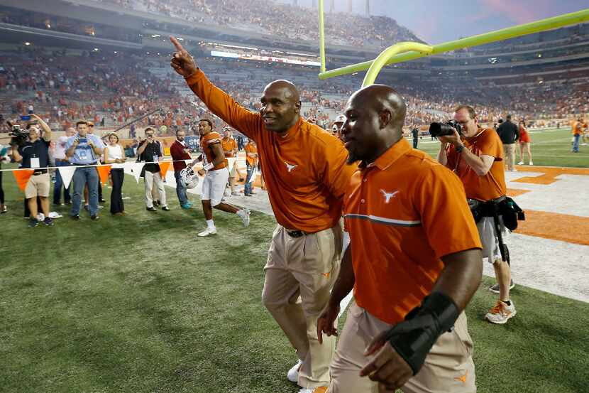 Texas head coach Charlie Strong (left) walks off the field after defeating Baylor 35-34 at...