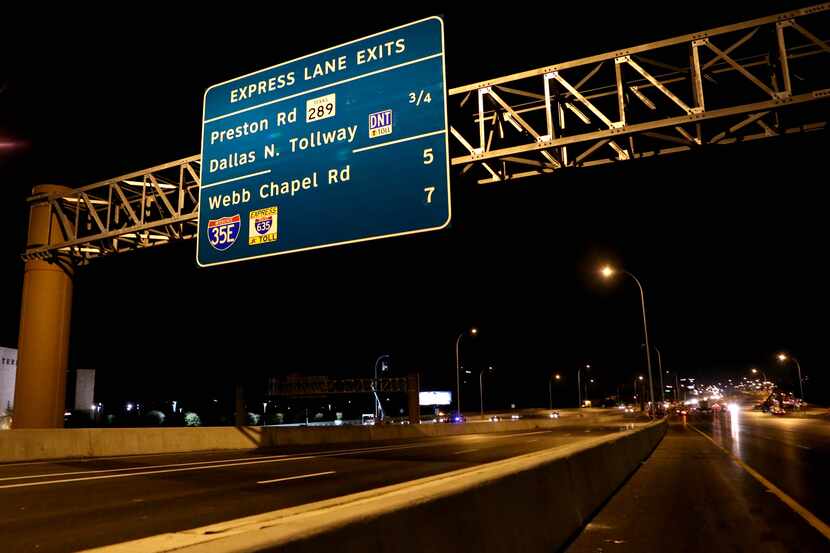 An express lane exit sign hangs over the new LBJ Express tolling lanes. The freeway's...