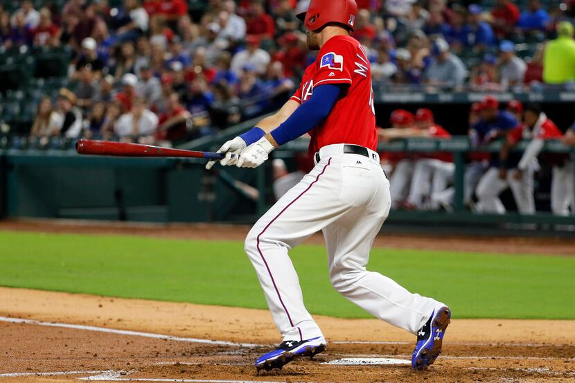 Texas Rangers third baseman Will Middlebrooks follows through on a bases loaded ground out...