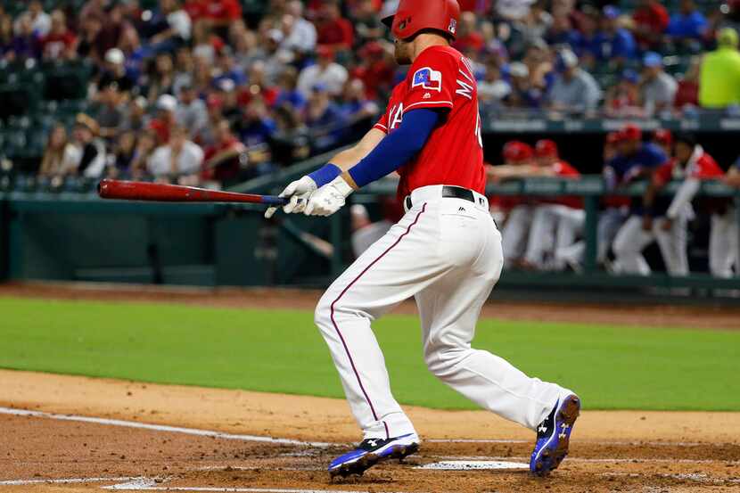 Texas Rangers third baseman Will Middlebrooks follows through on a bases loaded ground out...