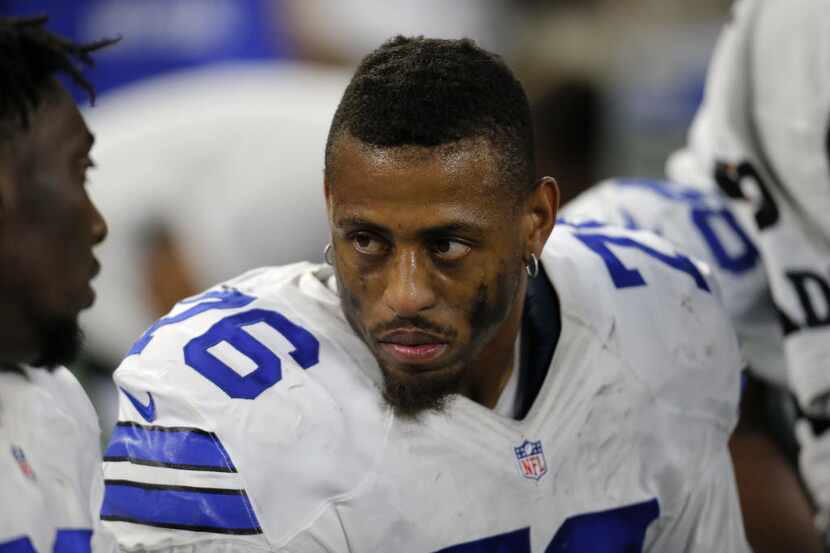 Dallas Cowboys' Greg Hardy (76) talks with teammates on the bench in the second half of an...