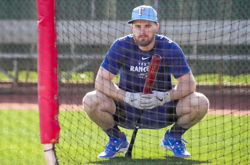 Texas Rangers infielder Jared Walsh waits to take batting practice during a spring training...