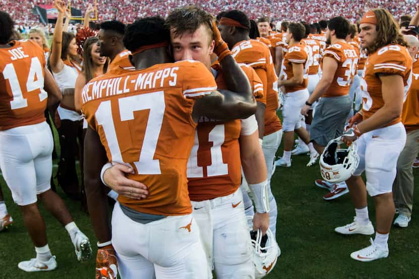 Texas Longhorns quarterback Sam Ehlinger (11) gets a hug from wide receiver Reggie...