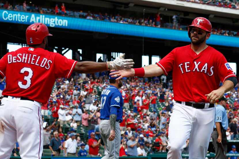 Texas Rangers first baseman Mitch Moreland, right, celebrates his run scored with Delino...