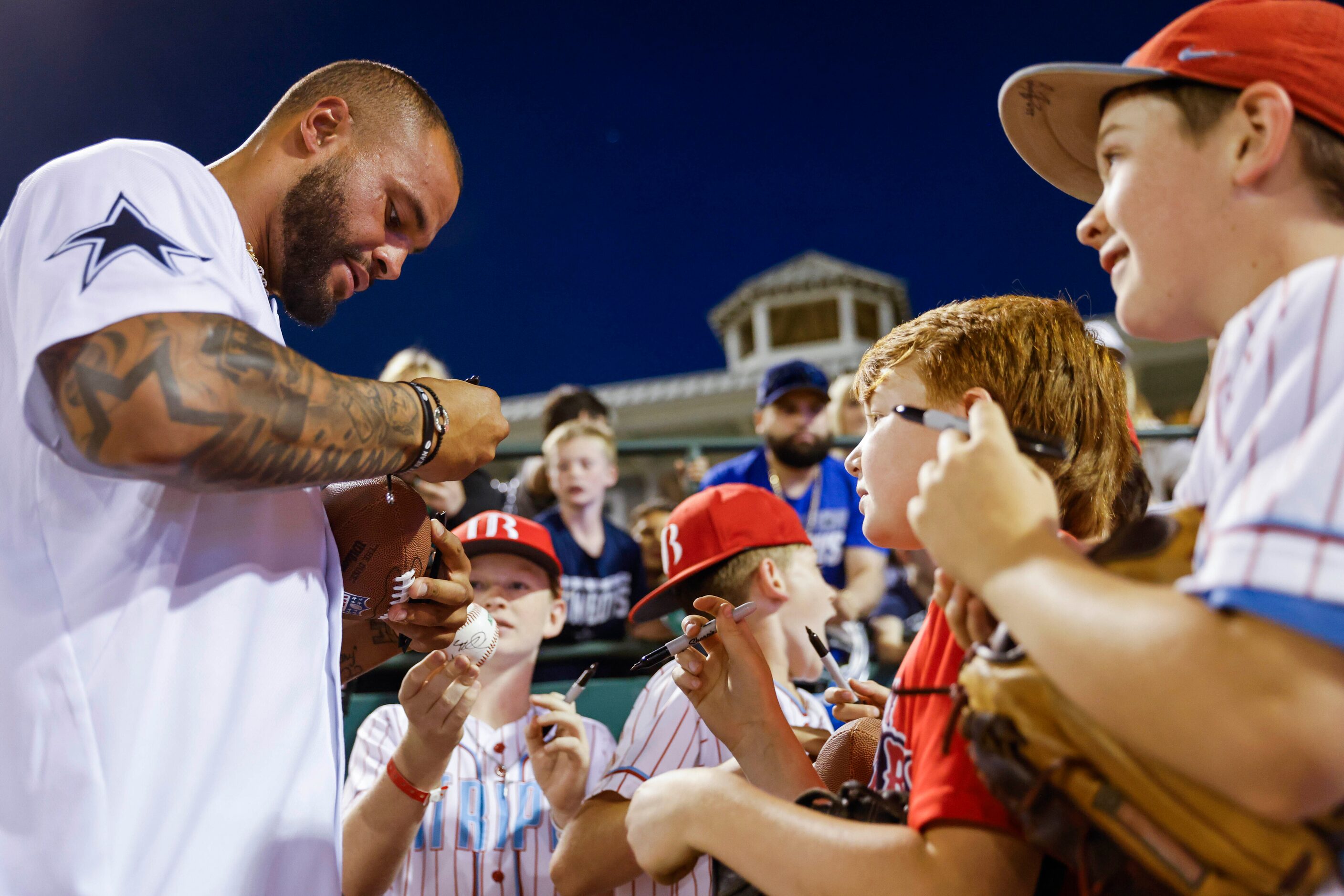 Dallas Cowboys QB Dak Prescott gives autograph to young fans after the annual home run derby...